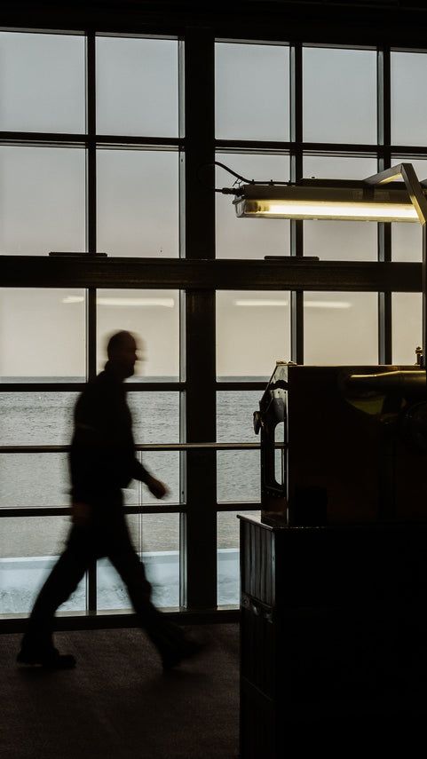 Person walking in a modern interior with large windows